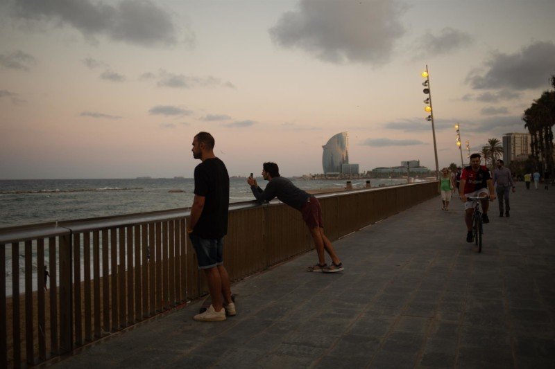 Dos hombres miran el paisaje frente a la playa de la Barceloneta, a 4 de agosto de 2021, en Barcelona, Catalunya (España). - David Zorrakino - Europa Press
