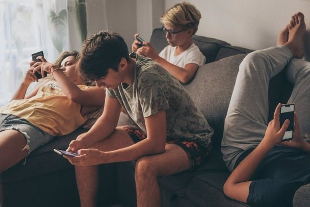 Archivo - Grupo de adolescentes sentados mirando sus móviles. - FABIO PRINCIPE/ISTOCK - Archivo
