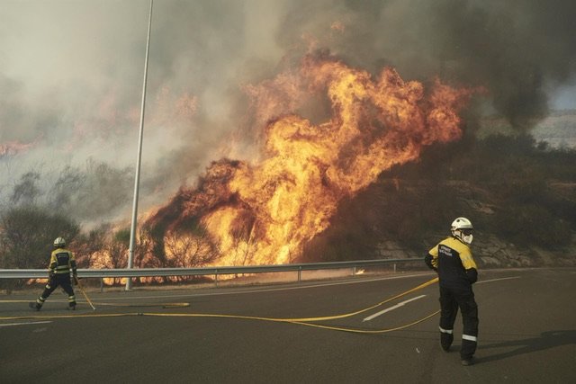 Foto: Bomberos trabajando en la extinción de un incendio declarado en el monte Ezkaba, cerca de Pamplona. - EDUARDO SANZ